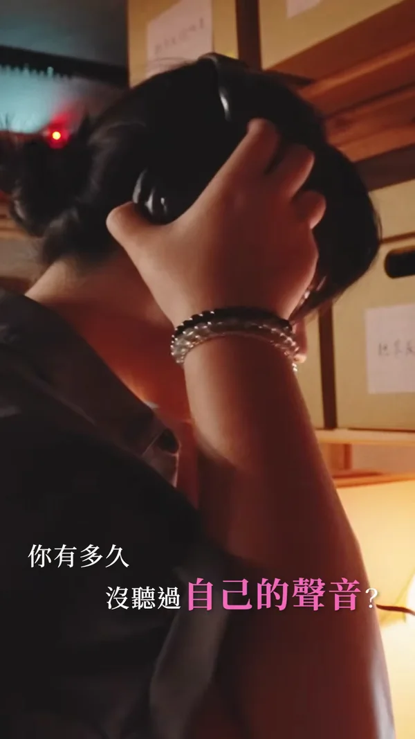 形象影片封面：昏暗的房間裡，一個人雙手扶著頭上的耳機，下方字幕寫著「你有多久沒聽過自己的聲音？」